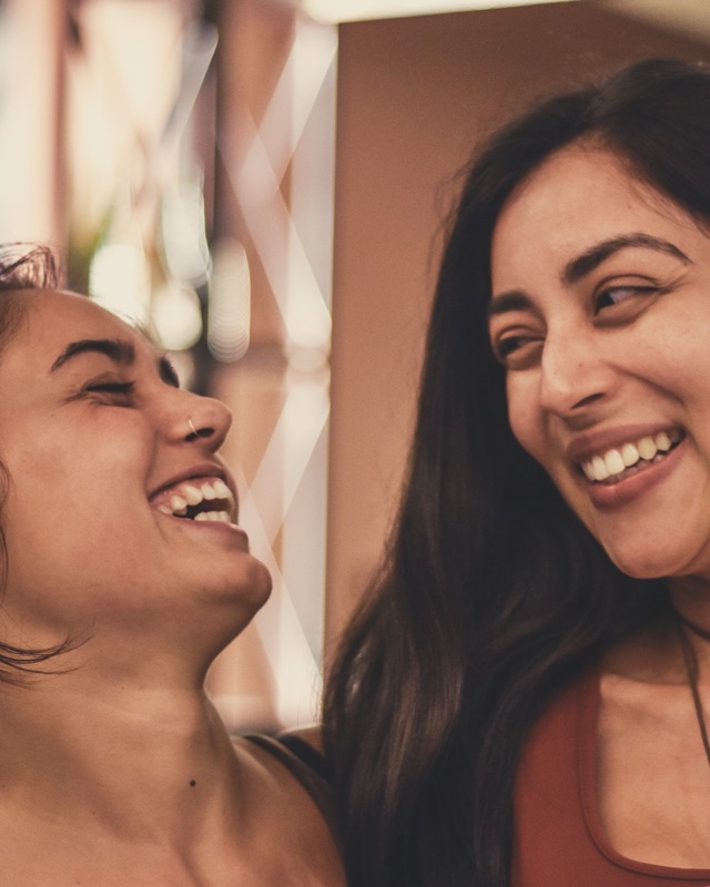 Two participants laughing together at a language-exchange event